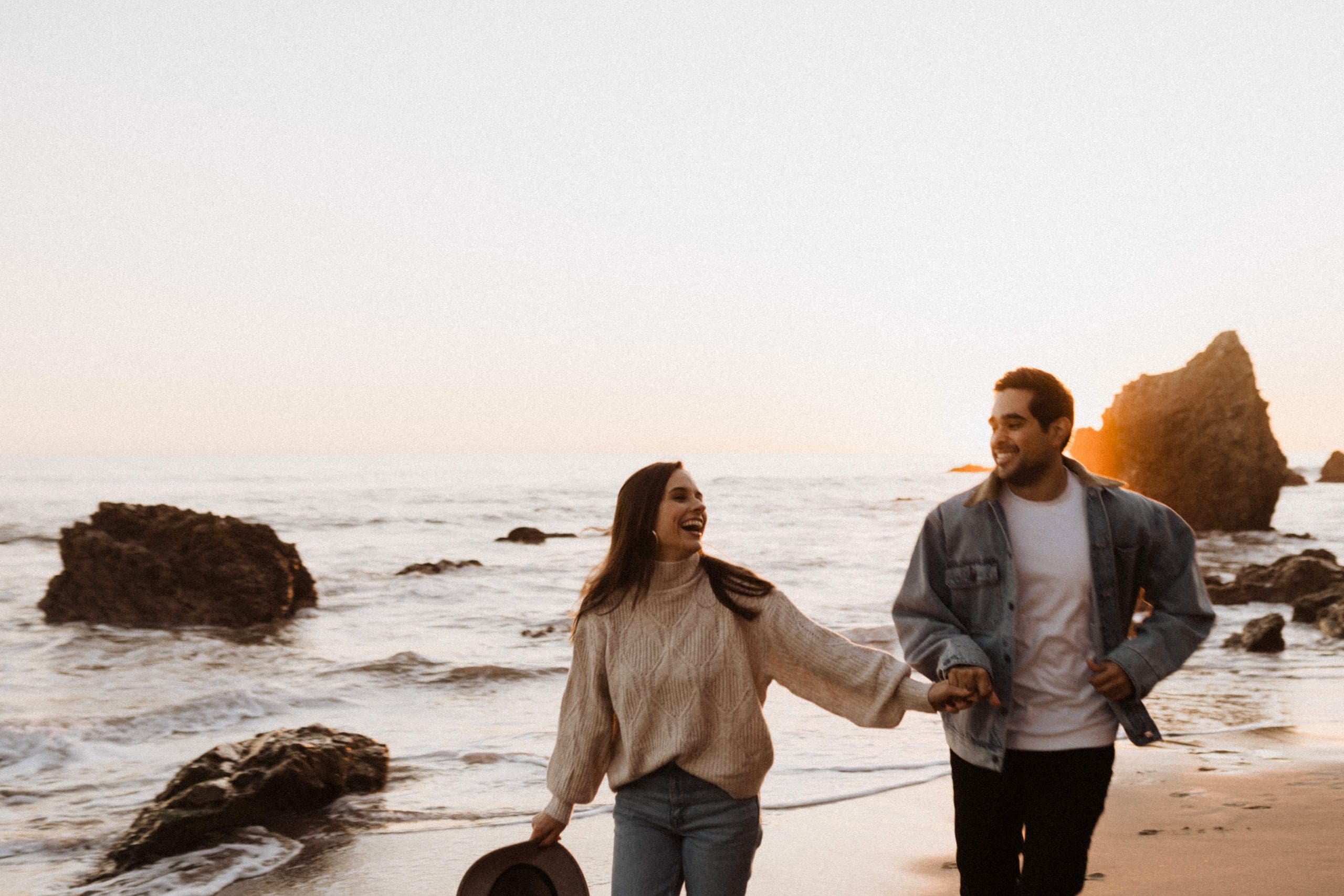 Couple Running on El Matador Beach | Kelly O'Connor Photography | Austin Based Wedding Photographer | Malibu, California Engagement Session | couples photos, bride to be, engagement photos, outfit ideas for engagement photos, destination photo session, beach photos, grainy photos, photos of couple on beach | via kellyoconnorphotography.com