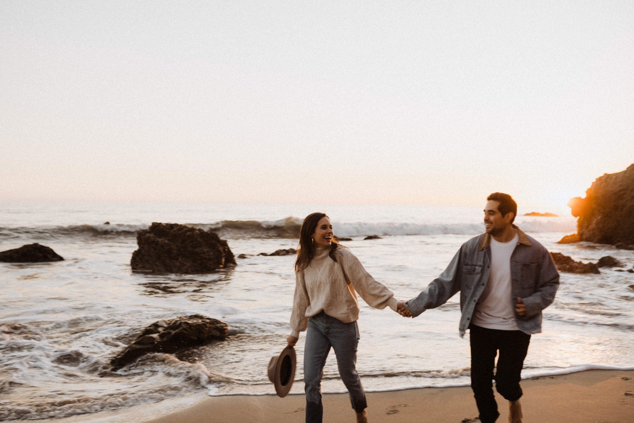 Couple Running on El Matador Beach | Kelly O'Connor Photography | Austin Based Wedding Photographer | Malibu, California Engagement Session | couples photos, bride to be, engagement photos, outfit ideas for engagement photos, destination photo session, beach photos, grainy photos, photos of couple on beach | via kellyoconnorphotography.com