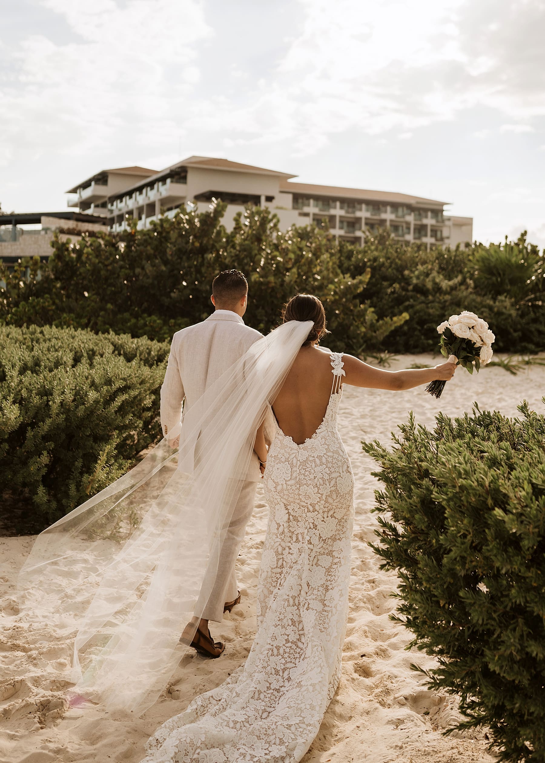 Bride and groom walking away after beach ceremony
