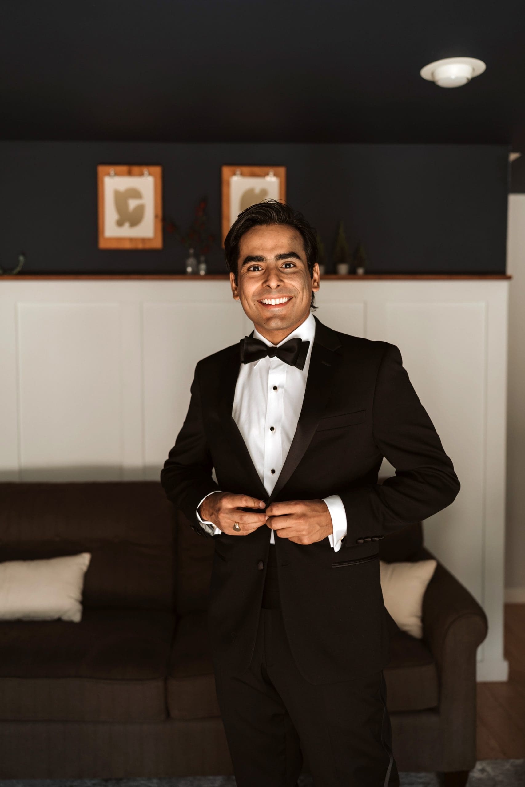 Groom buttoning tux jacket