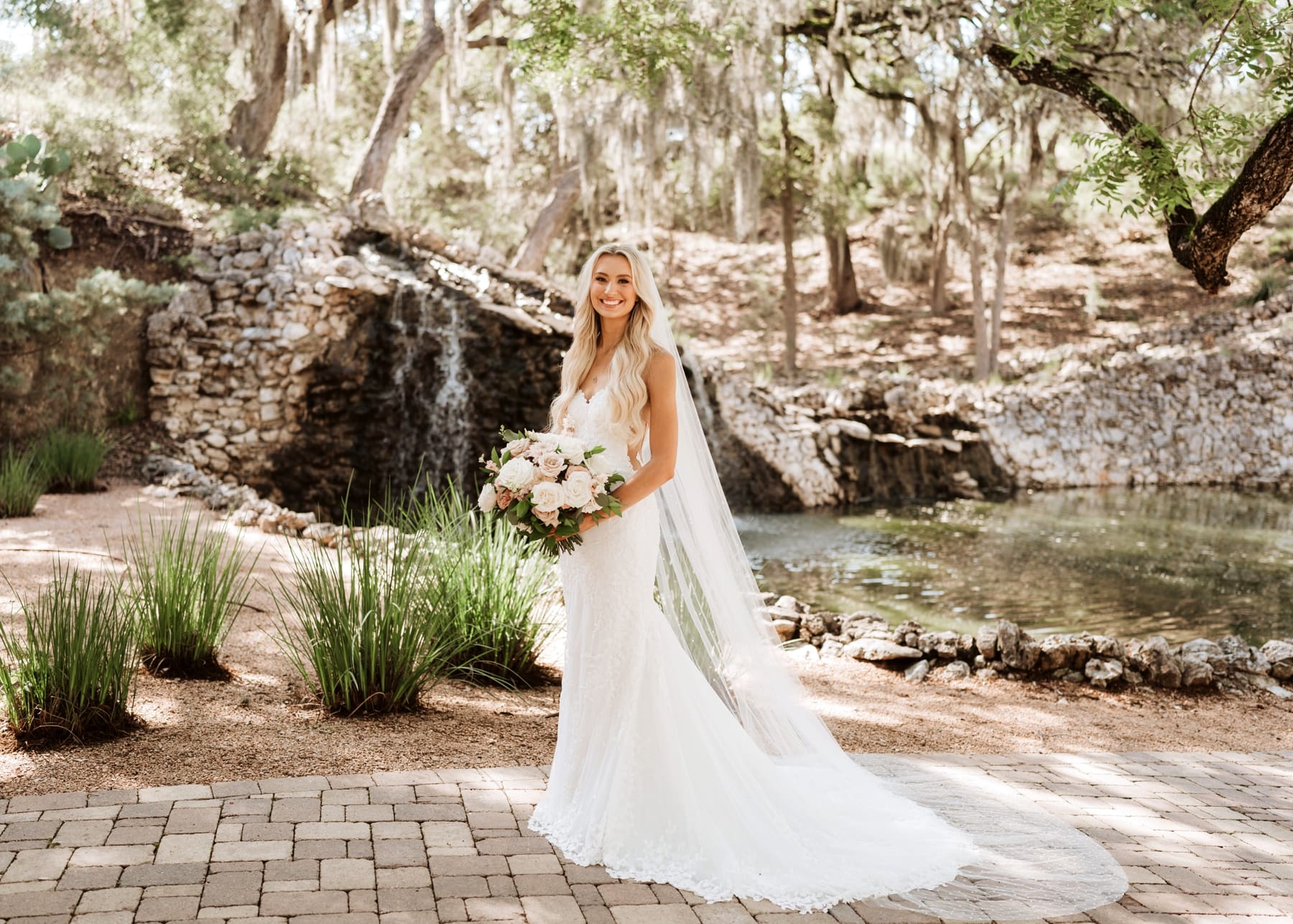 Bride standing in front of waterfall at Hayes Hollow at Hidden Falls