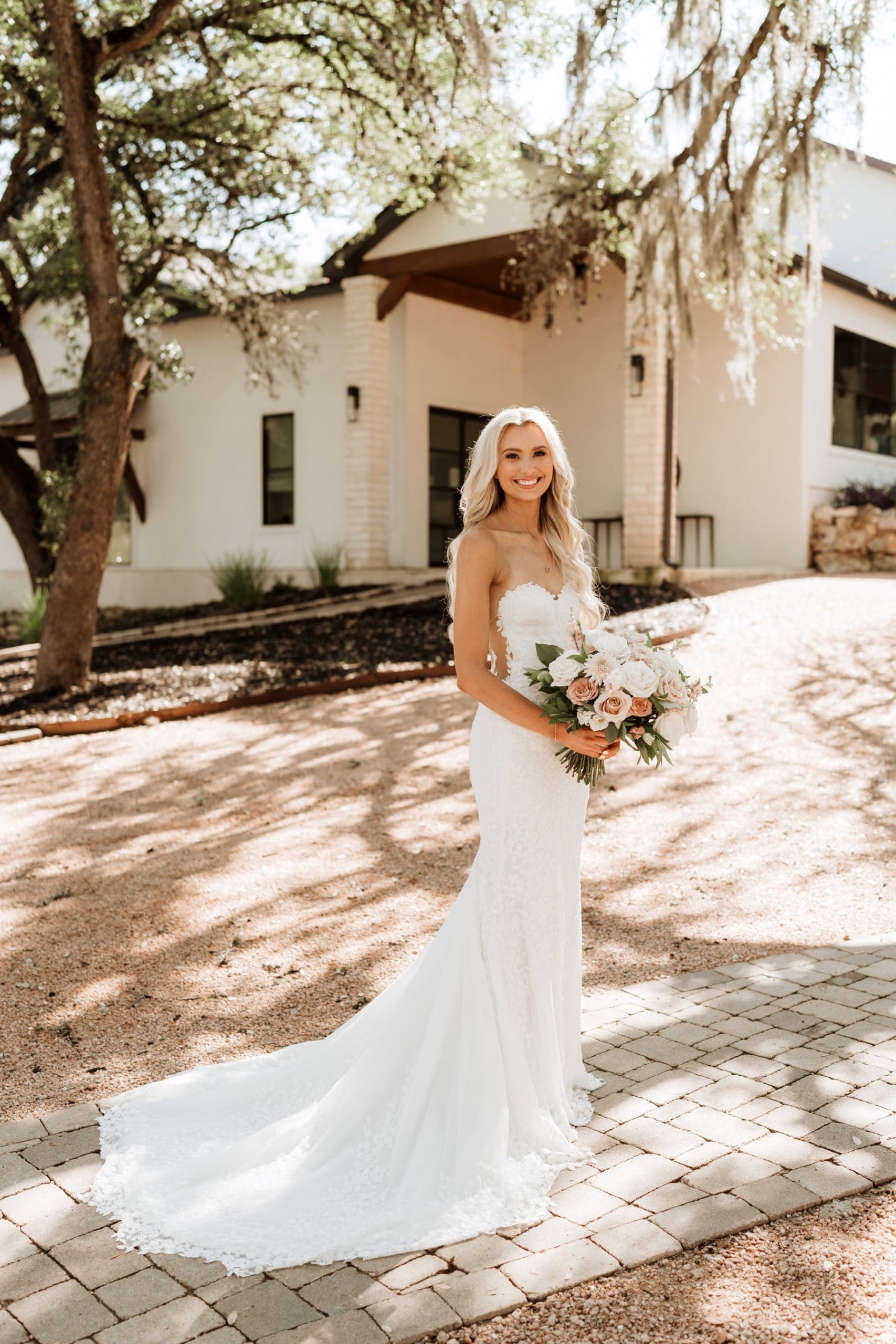 Bride holding bouquet full of pink and white flowers standing in front of Hayes Hollow at Hidden Falls