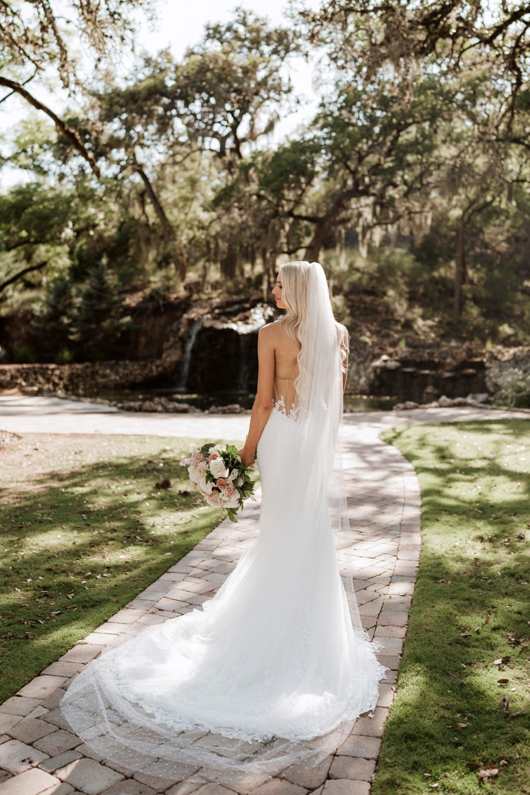 Bride wearing veil looking over shoulder during bridal portraits