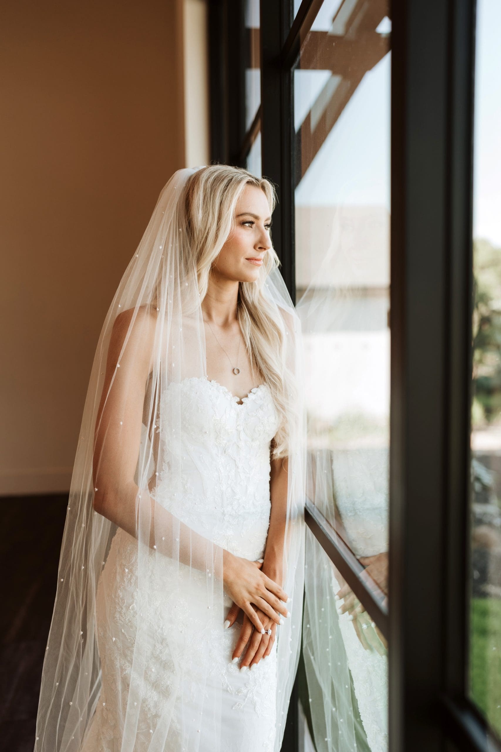 Bride looking out window during bridal portraits at Hayes Hollow at Hidden Falls