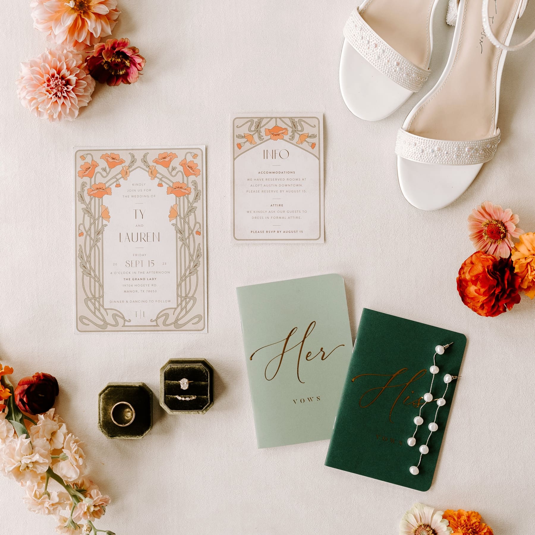 Wedding details shot with green vow books, green ring boxes, and green and orange wedding invitations 