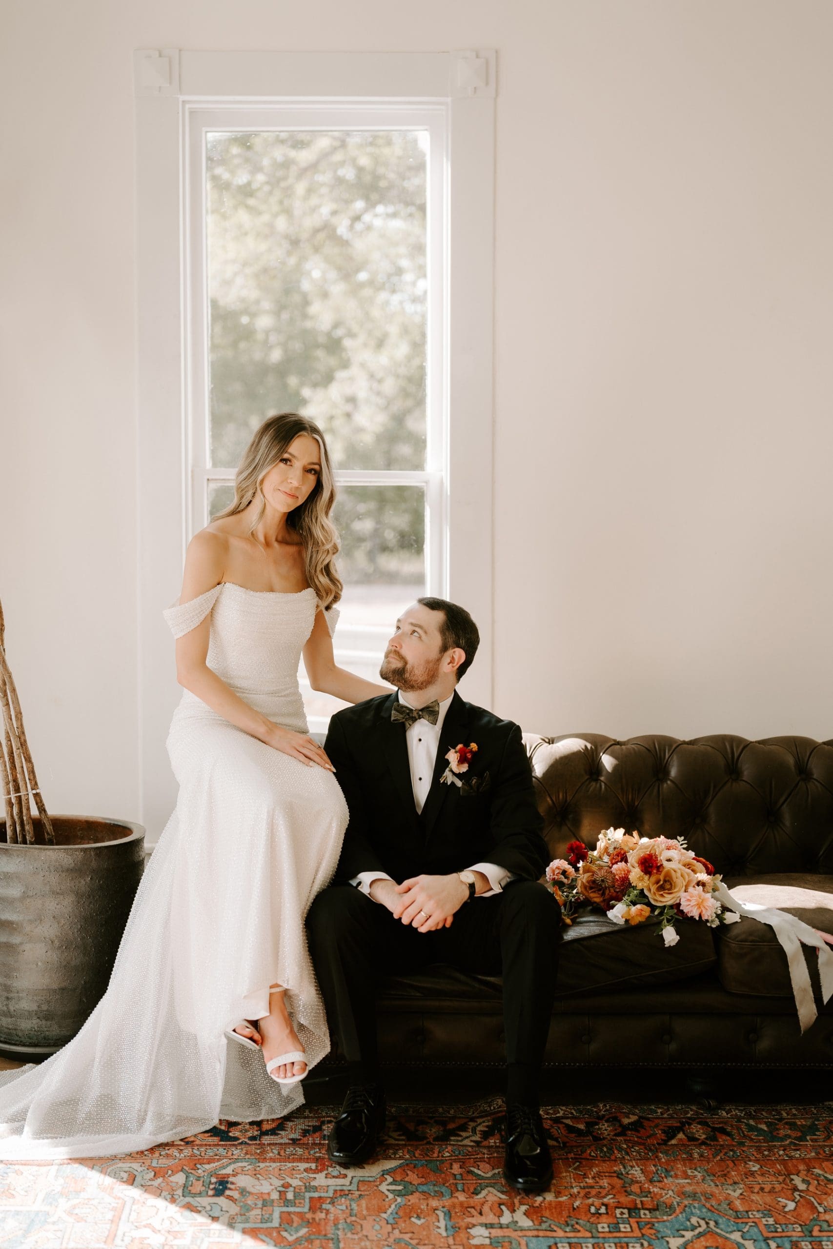 Groom sitting on couch looking up at bride at The Grand Lady Austin