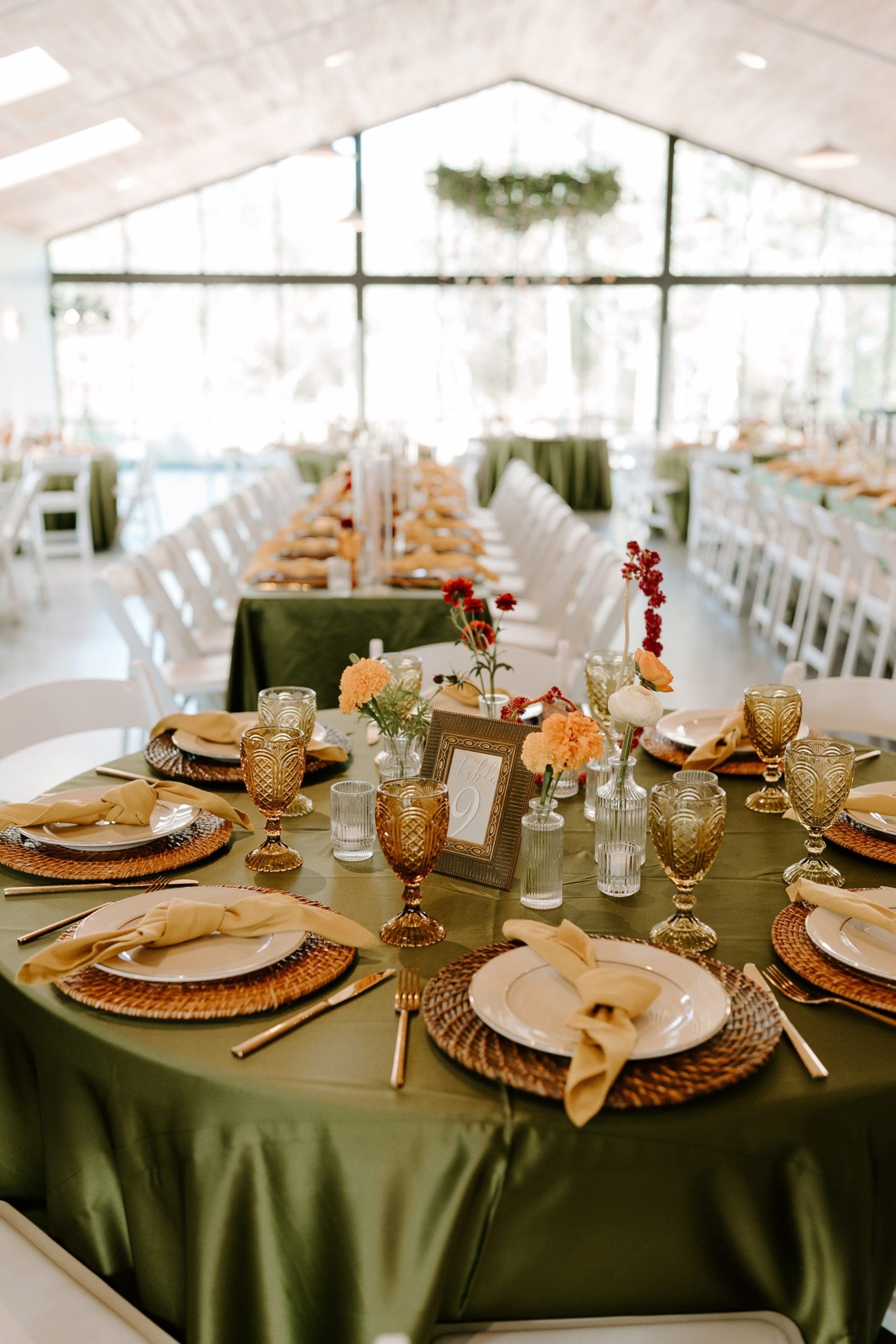 Boho wedding reception featuring green tablecloths and eclectic table decor