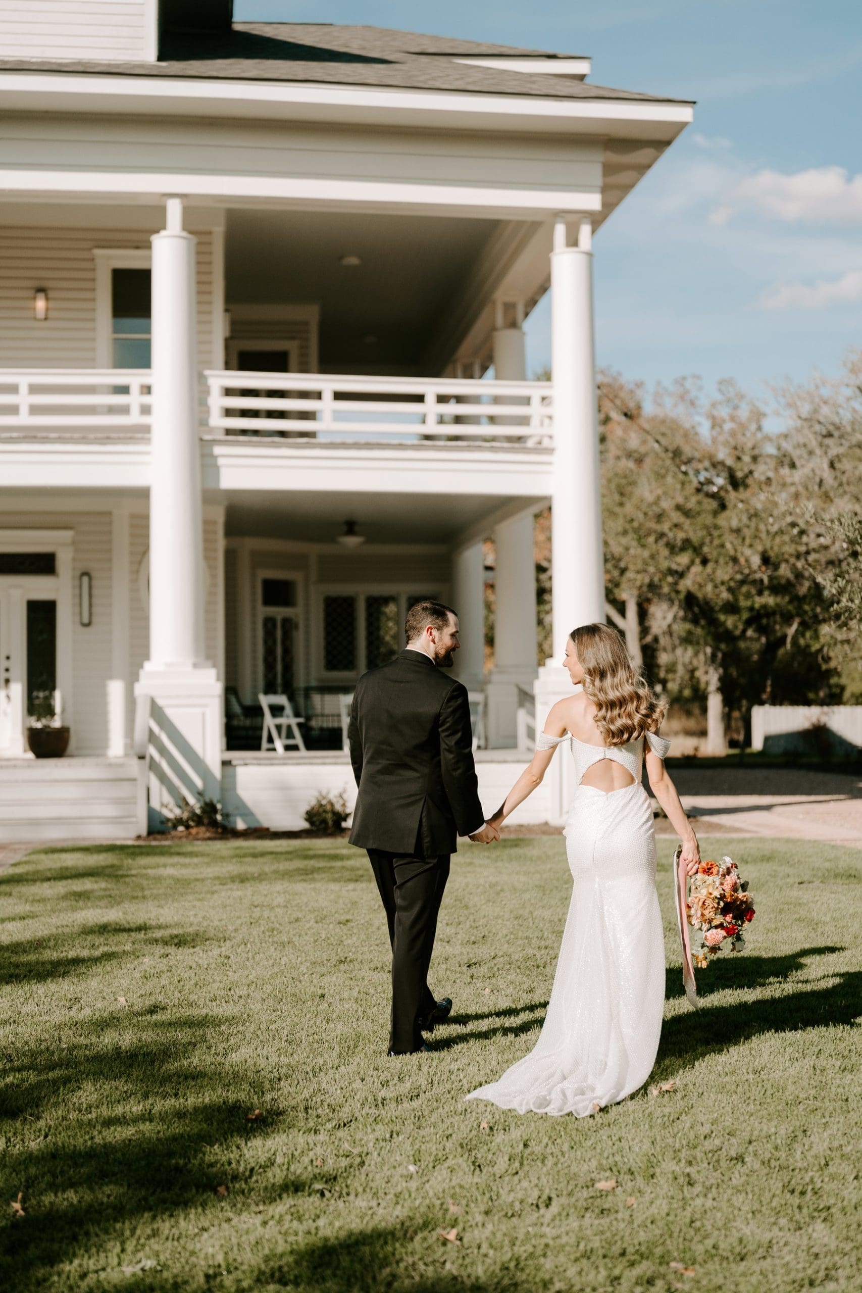 Bride and groom holding hands and walking in front of The Grand Lady Austin