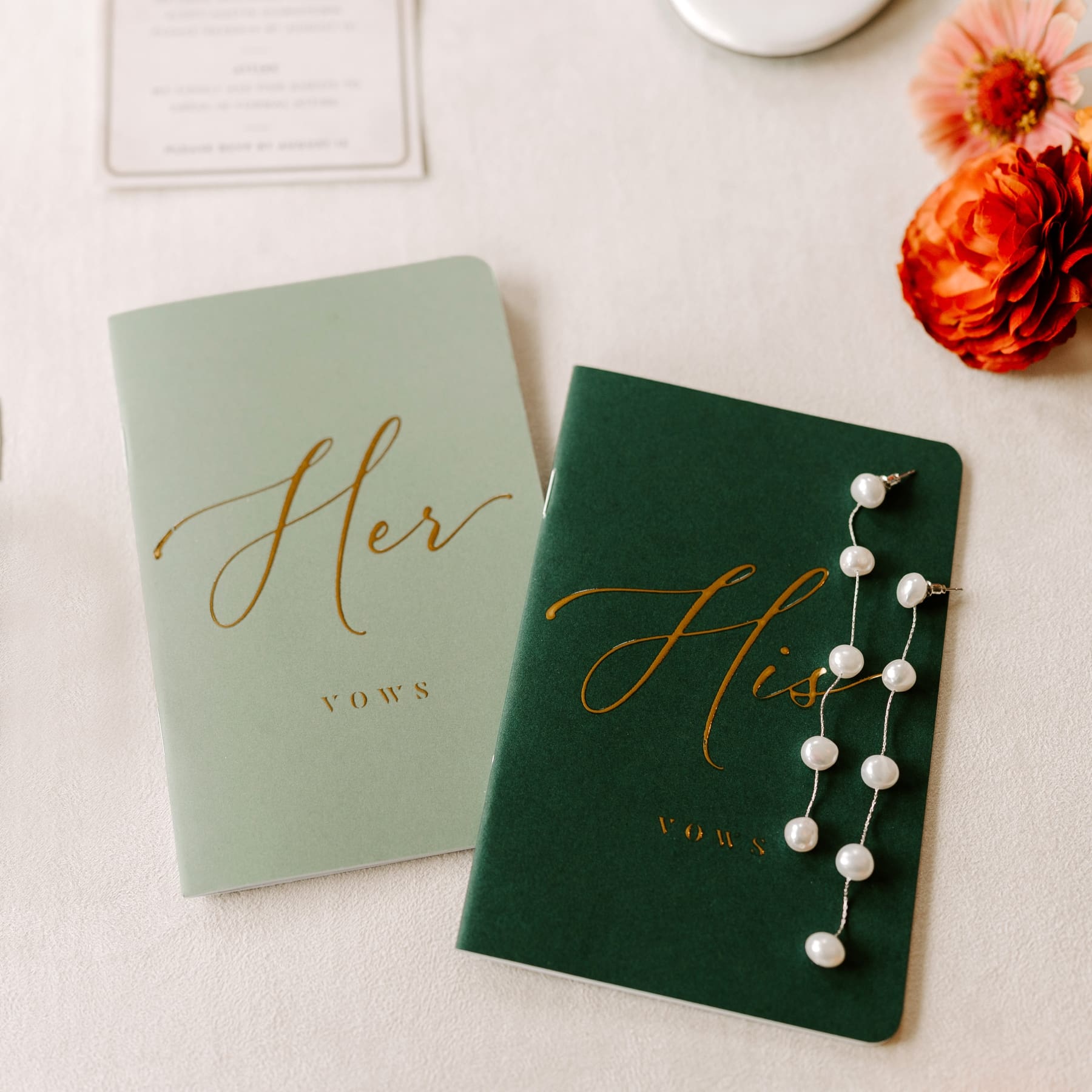 Green his and hers vow books with long pearl earrings