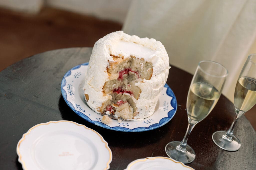 Half eaten preserved wedding cake top with champagne on the table