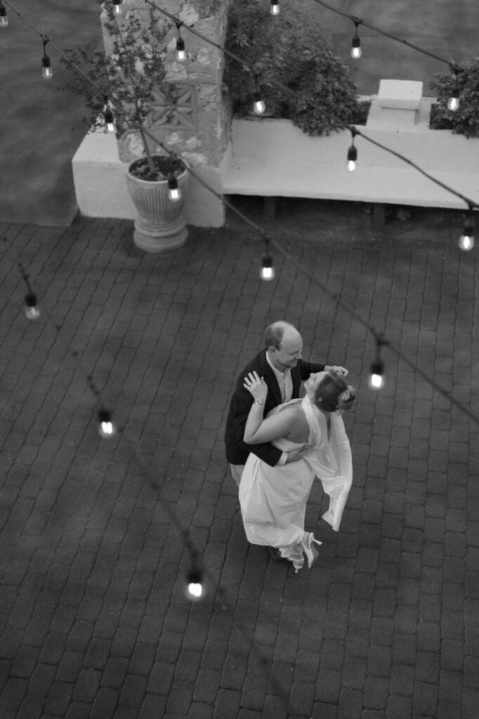 Romantic black and white portrait of couple dancing together in the courtyard of Villa Antonia during their anniversary photo session
