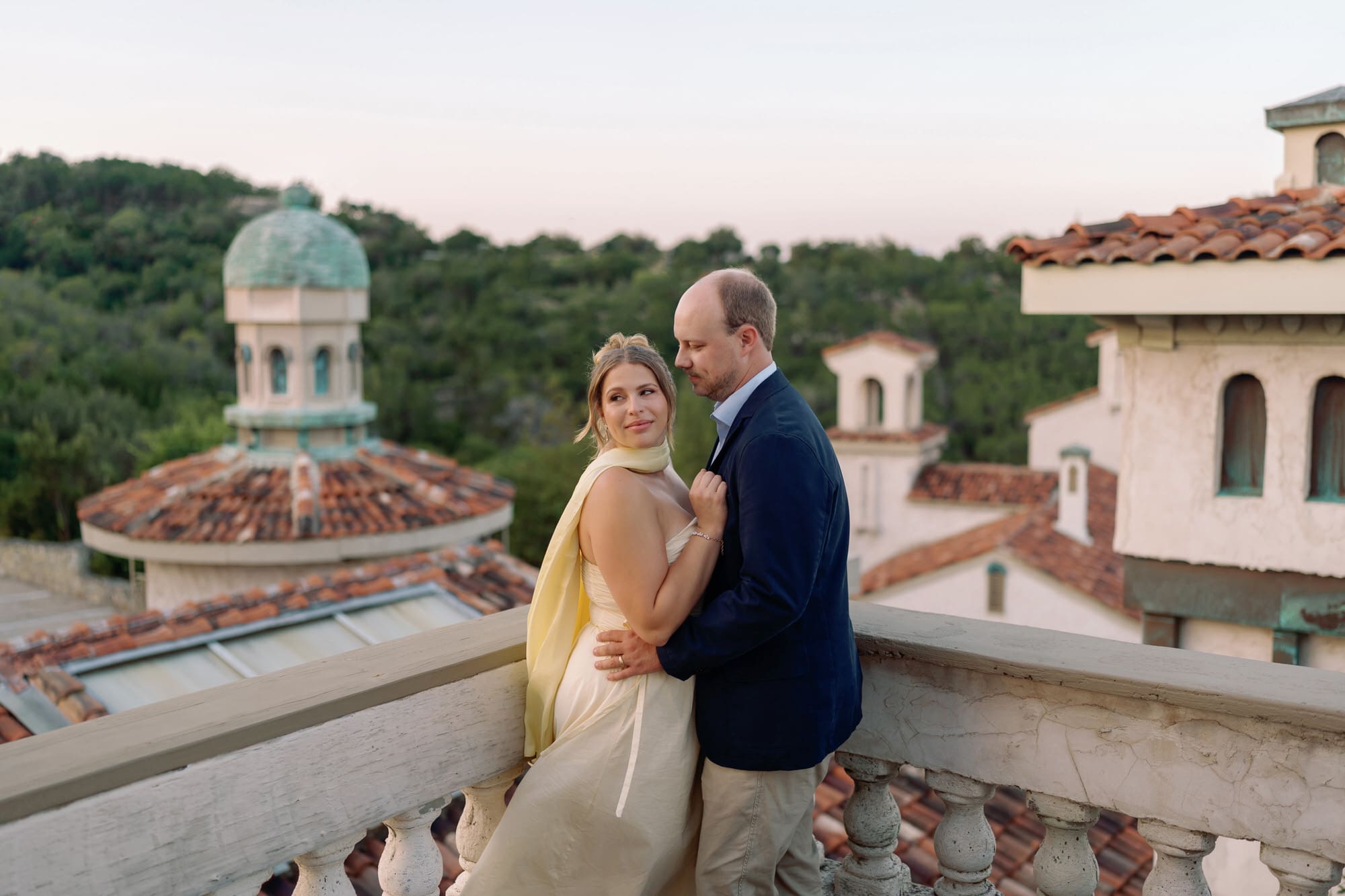 Romantic portrait of couple on the balcony at Villa Antonia, surrounded by Tuscan-style architecture and warm evening light.